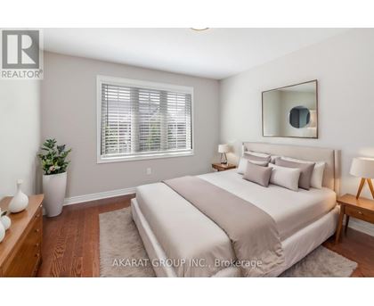 A well-lit bedroom with a large bed and a potted plant.