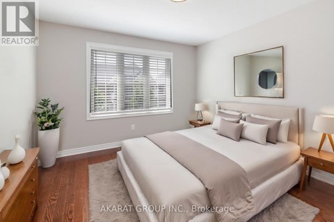 A well-lit bedroom with a large bed and a potted plant.