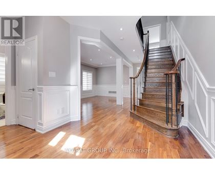 A spacious room with a wooden staircase and white walls.