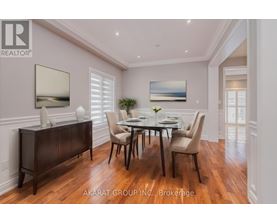 A dining room with a table set for four and a large painting on the wall.