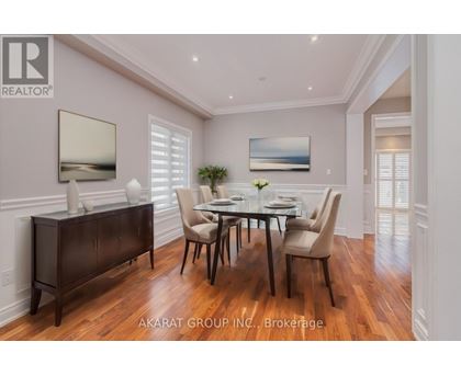 A dining room with a table set for four and a large painting on the wall.