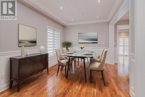 A dining room with a table set for four and a large painting on the wall.