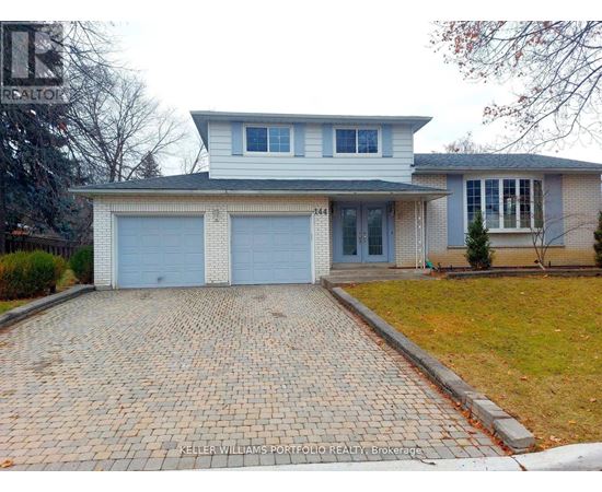 A house with a brick driveway in front of it.