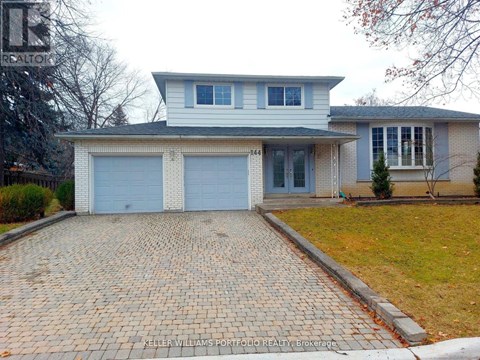 A house with a brick driveway in front of it.