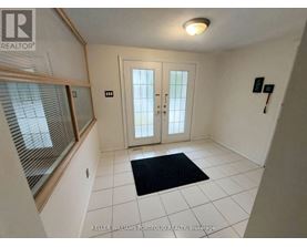 A hallway with a black doormat in front of a white door.