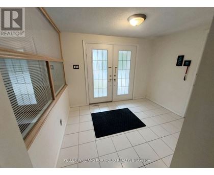 A hallway with a black doormat in front of a white door.