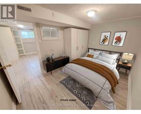 A bedroom with a bed, nightstand, and a window.
