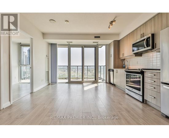 A spacious kitchen with wooden floors and modern appliances.