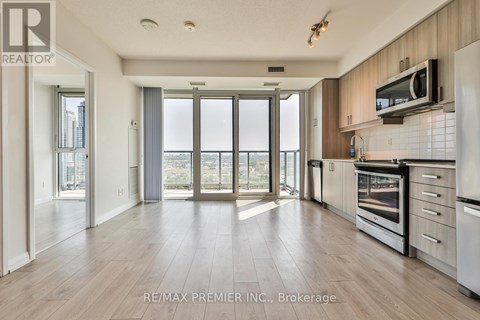 A spacious kitchen with wooden floors and modern appliances.