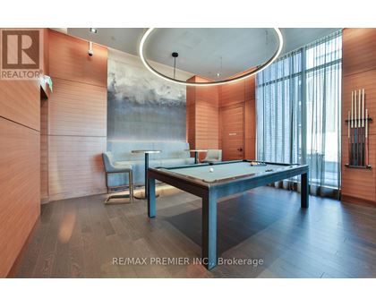 A room with a pool table and a large painting on the wall.