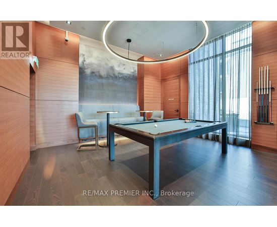 A room with a pool table and a large painting on the wall.