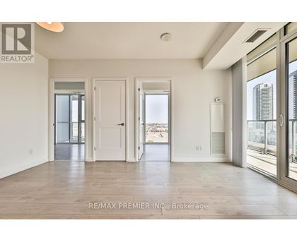 A spacious room with a view of the city through large windows.