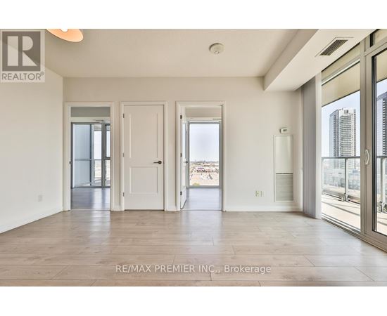 A spacious room with a view of the city through large windows.