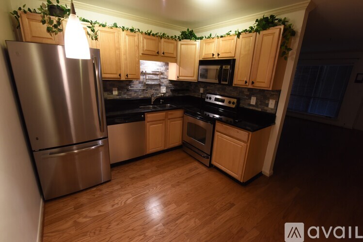 A kitchen with wooden cabinets and a stainless steel refrigerator.
