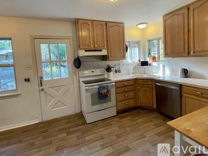 A kitchen with wooden cabinets and a white stove top oven.