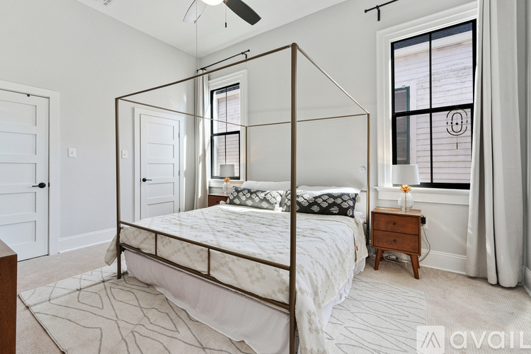 A bedroom with a four poster bed and a ceiling fan.