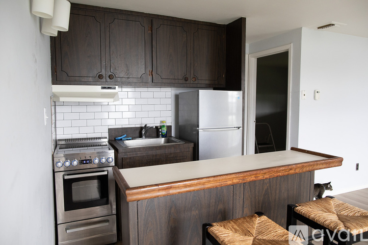 A kitchen with dark wood cabinets and a white fridge.