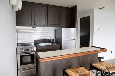 A kitchen with dark wood cabinets and a white fridge.