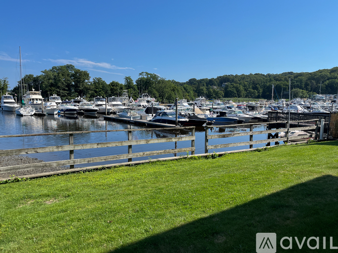 A marina with boats docked and green grass in the foreground.