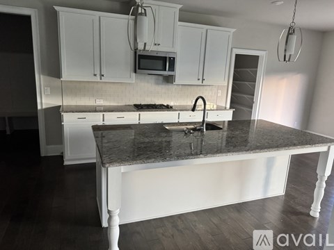 A kitchen with white cabinets and a granite countertop.