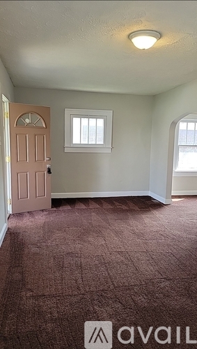 A room with a carpeted floor and a door.