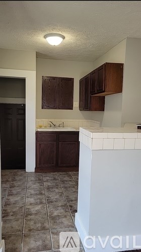 A kitchen with brown cabinets and a white counter.