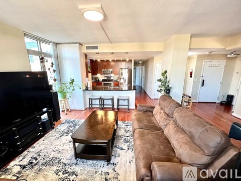 A living room with a brown leather couch and a wooden coffee table.