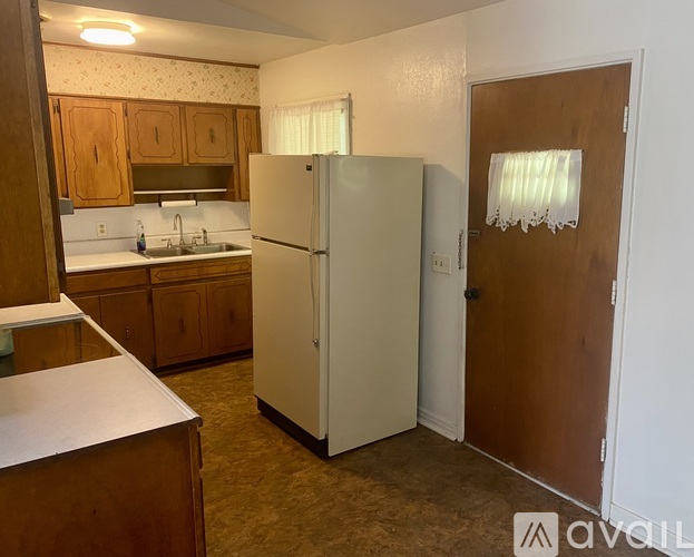 A kitchen with a white fridge and wooden cabinets.