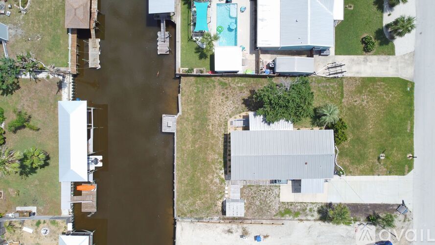 A bird's eye view of a house with a pool and a dirty water body.