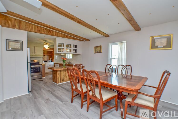 A dining room with a wooden table and chairs.