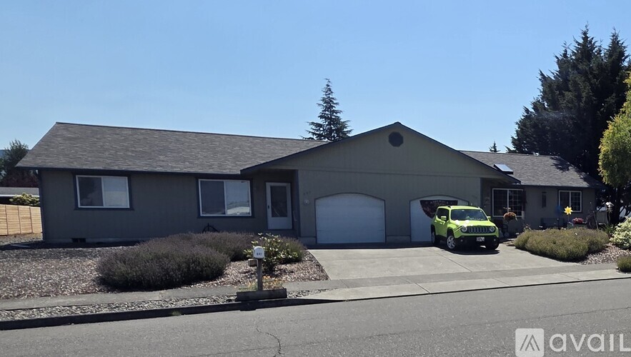 A house with a grey roof and a white garage door is shown.