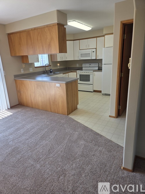 A kitchen with a white refrigerator and a wooden island.