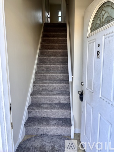 A staircase with a white door at the top.