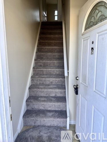 A staircase with a white door at the top.