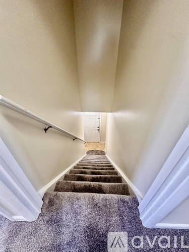 A staircase with a carpeted runner and white railings.