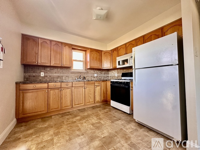 A kitchen with wooden cabinets and a white refrigerator.