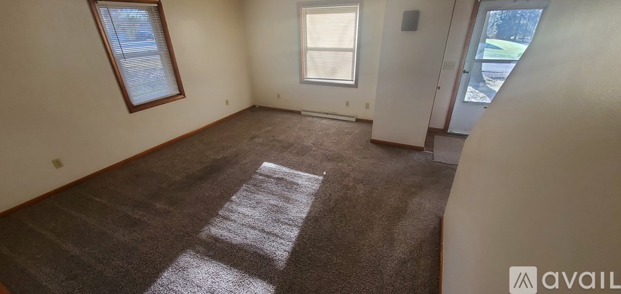 A room with a carpeted floor and a window.