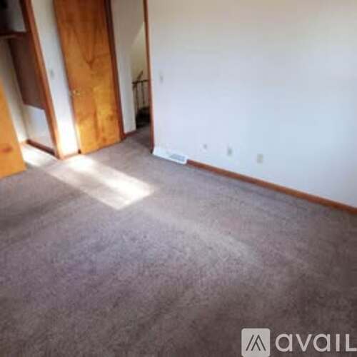 A room with a carpeted floor and a white wall.