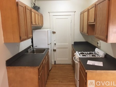 A kitchen with wooden cabinets and a white refrigerator.