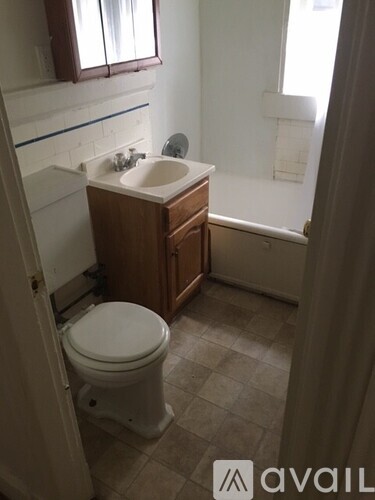 A small bathroom with a toilet, sink and a window.