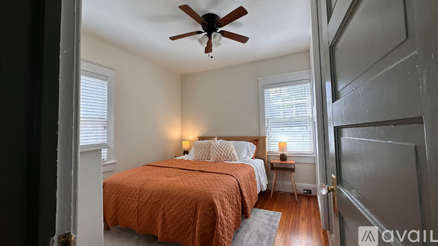 A bedroom with two beds and a ceiling fan.