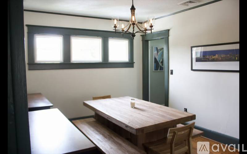 A dining room with a wooden table and chairs.