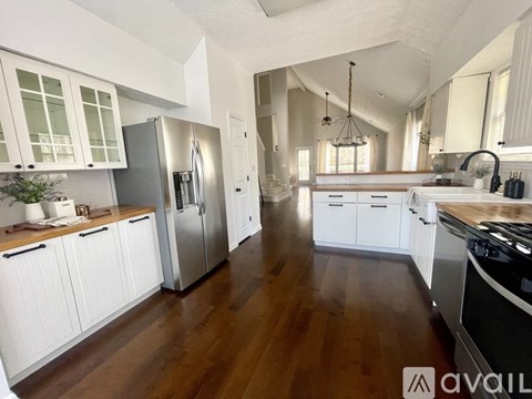 A kitchen with white cabinets and a wooden floor.