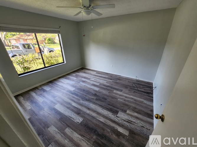 A room with wooden flooring and a ceiling fan.