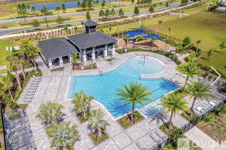 A pool surrounded by palm trees and a pavilion.