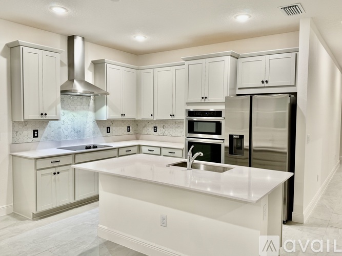 A modern kitchen with white cabinets and a central island.