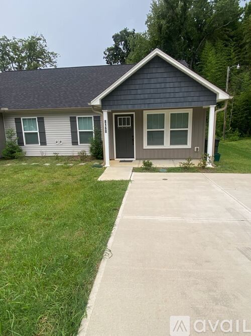 A small house with a grey roof and a black door.