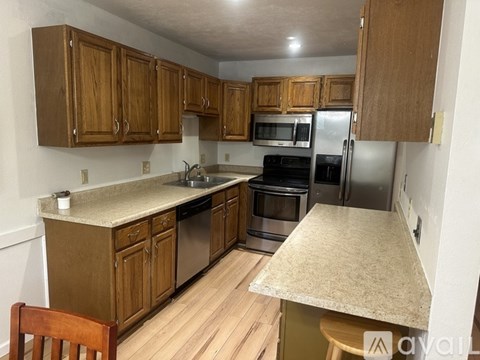A kitchen with wooden cabinets and stainless steel appliances.