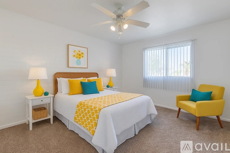 A bedroom with a bed, a chair, and a ceiling fan.