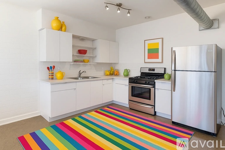 A kitchen with white cabinets and a stainless steel refrigerator.